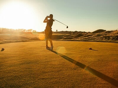 Sun Protection for Athletes: Why Skin Health Matters More Than You Think 1 a man swinging a golf club on a golf course