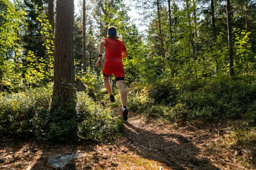 Staying Safe During Outdoor Sports: A Practical Guide for Athletes 2 a man in red running through a forest