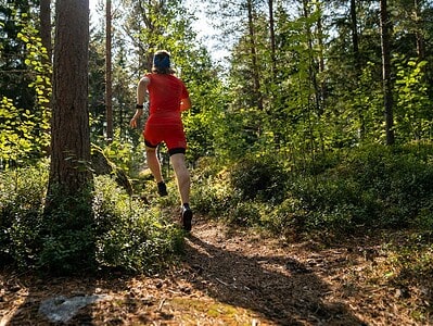 Staying Safe During Outdoor Sports: A Practical Guide for Athletes 2 a man in red running through a forest